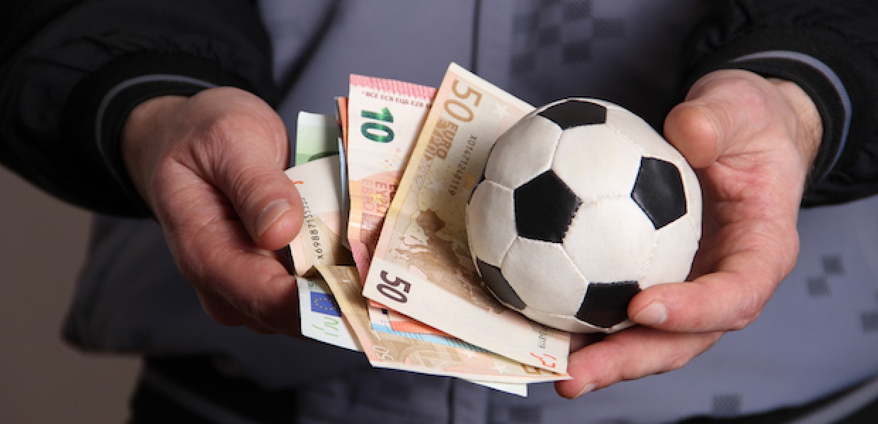 Man_holding_football_and_money_in_his_ha